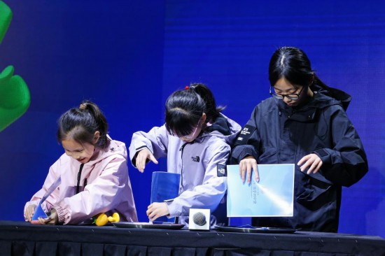 11月23日,小观众在浙江杭州举办的2024菠萝科学奖现场进行科学实验。新华社发